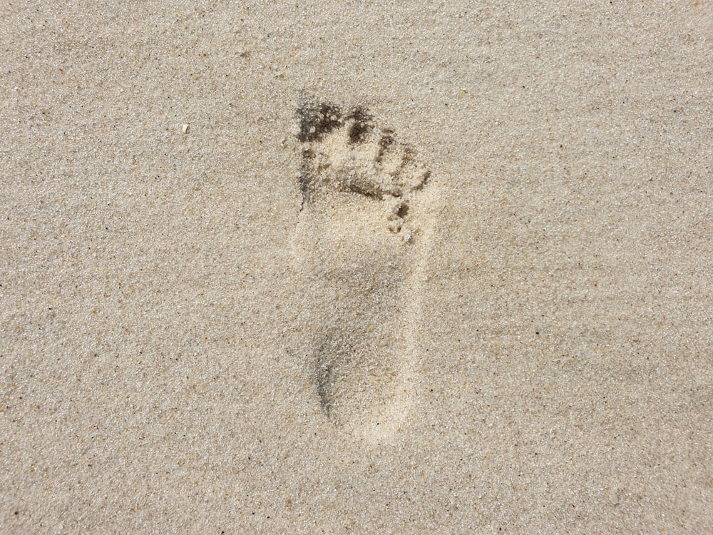 a foot print in the sand on a beach