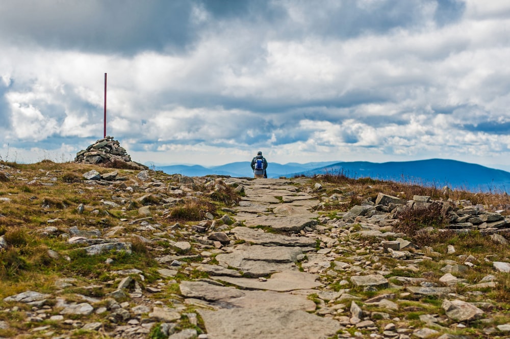 Un uomo in piedi sulla cima di una collina rocciosa