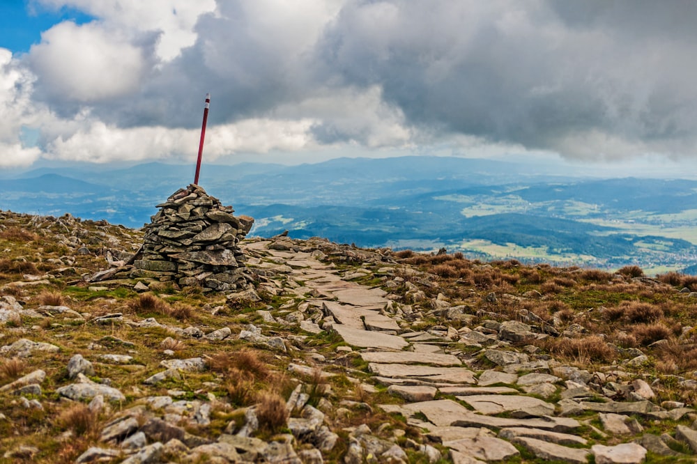 um caminho de pedra que leva a uma bandeira no topo de uma montanha