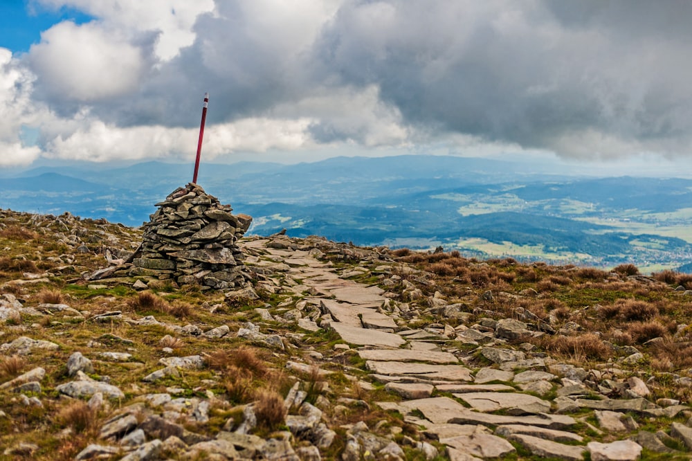 a stone path leading to a flag on top of a mountain