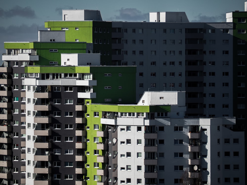 a group of buildings with green and white balconies