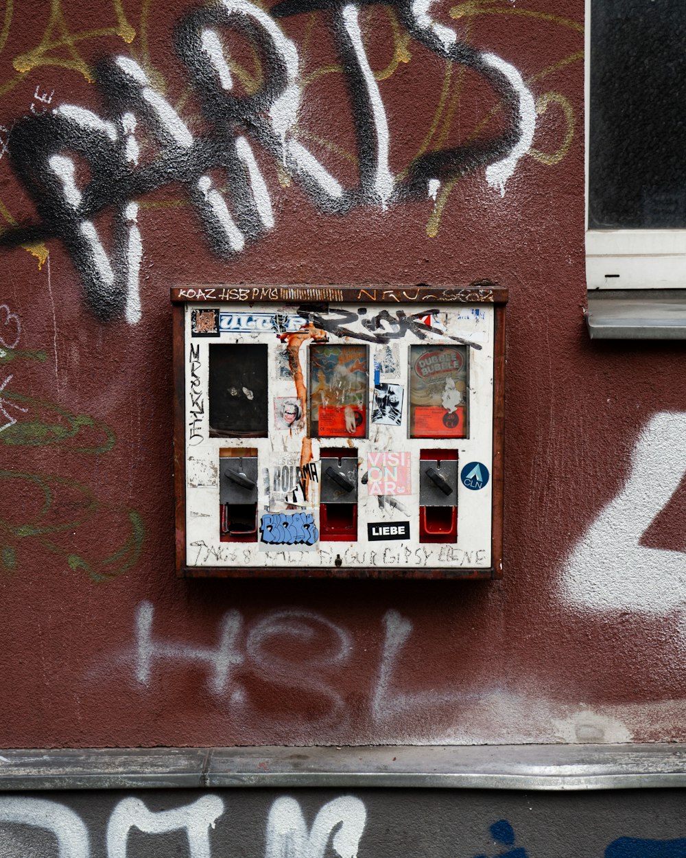 a red wall with some graffiti on it