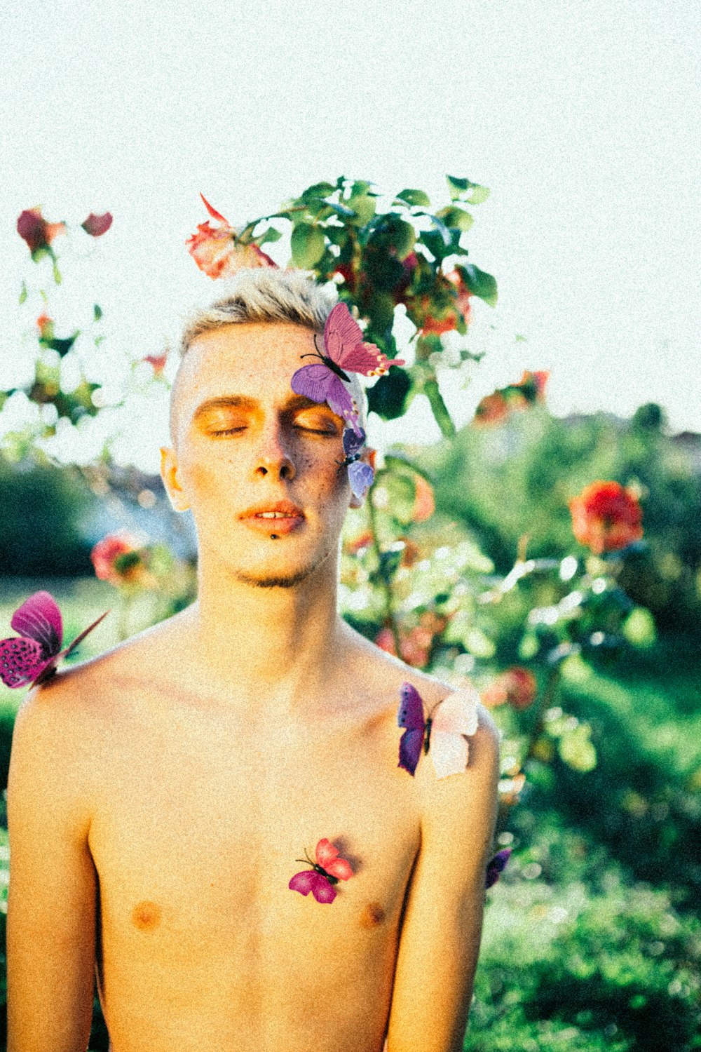 a shirtless man with flowers on his head