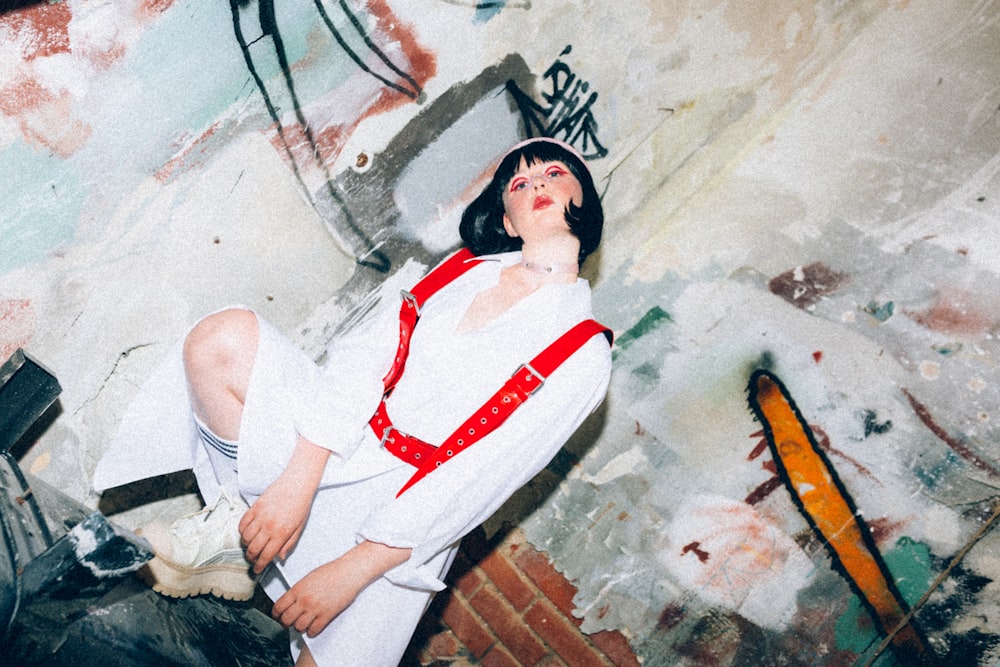 a woman in a white shirt and red suspenders