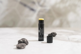 a close up of a tube of lipstick on a bed