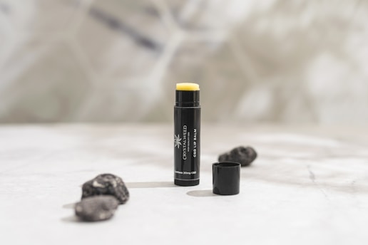 a close up of a tube of lipstick on a bed