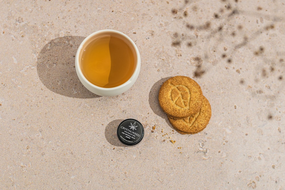 a cup of tea next to a cookie