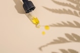 a dropper bottle filled with yellow liquid sitting on top of a table