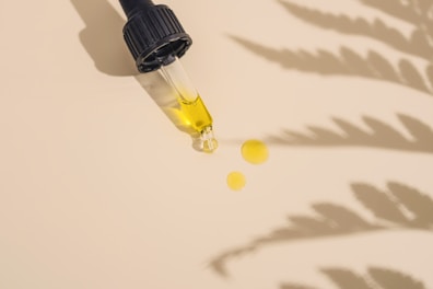 a dropper bottle filled with yellow liquid sitting on top of a table