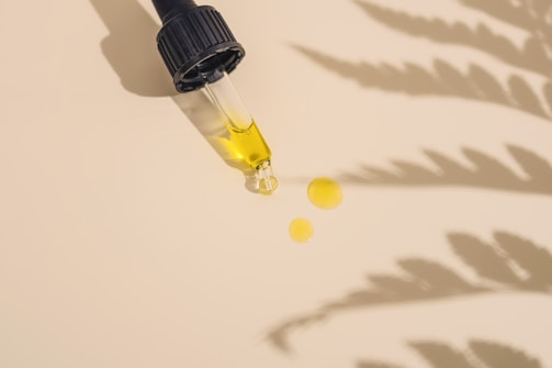 a dropper bottle filled with yellow liquid sitting on top of a table
