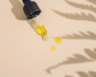 a dropper bottle filled with yellow liquid sitting on top of a table