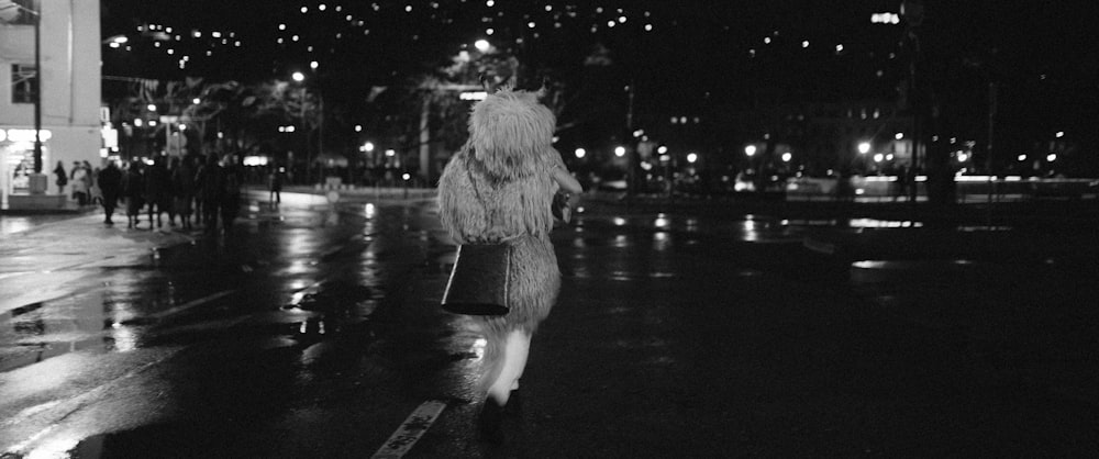 a woman walking down a street at night