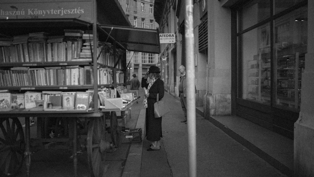 a black and white photo of people walking down a street