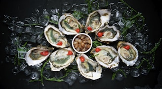 a plate of oysters on ice with a cherry in a bowl