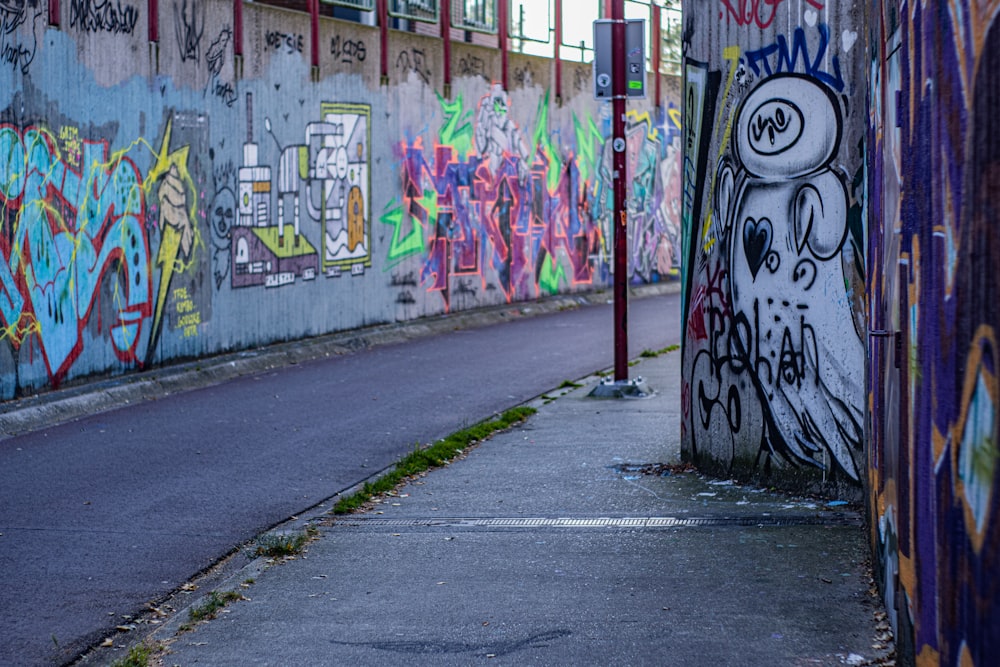 a wall covered in graffiti next to a street