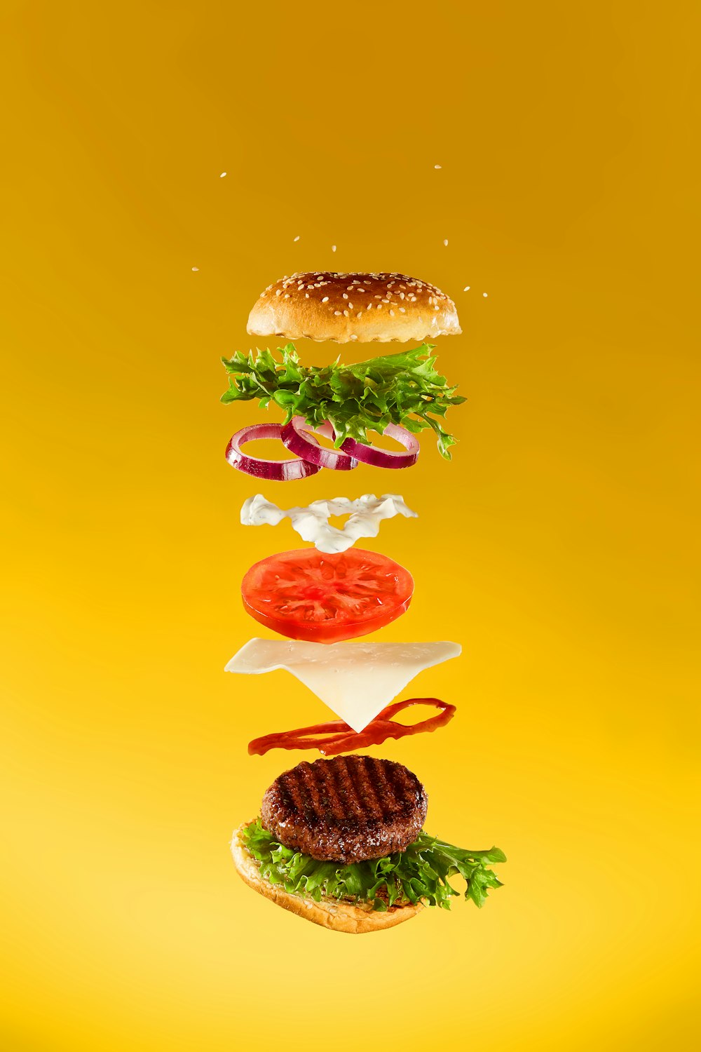 a hamburger flying through the air with a lot of toppings on it