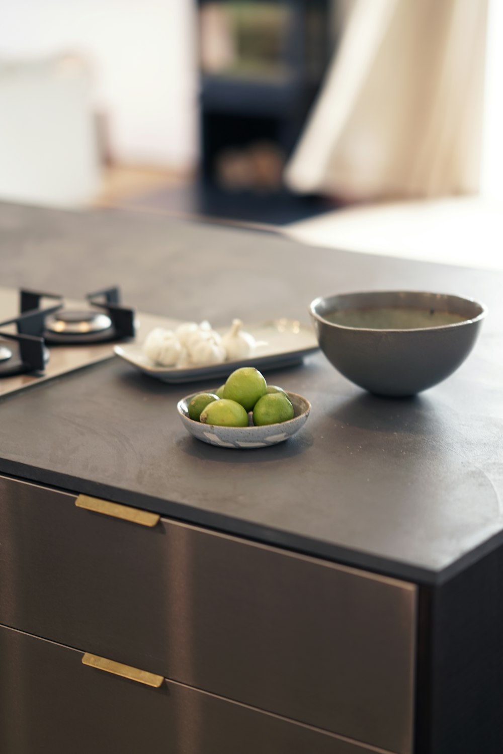 a bowl of green olives and a bowl of garlic on a counter