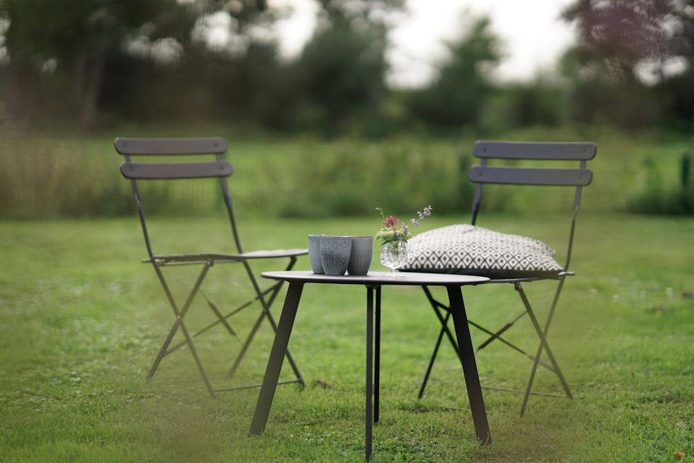 a couple of chairs sitting on top of a lush green field