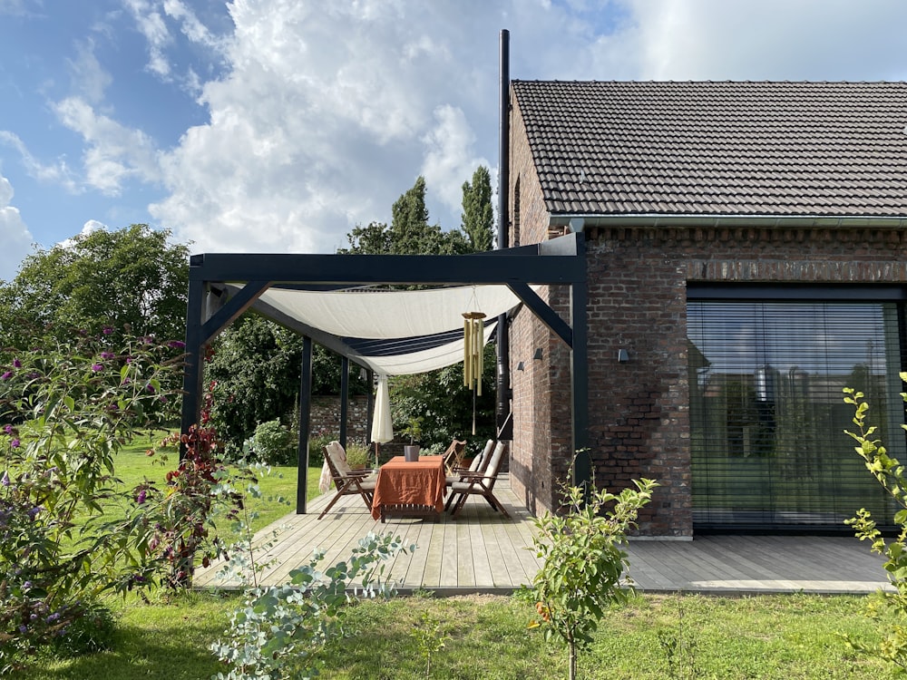 a covered patio with a table and chairs