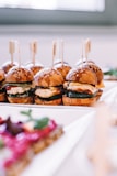 a row of mini sandwiches sitting on top of a white plate