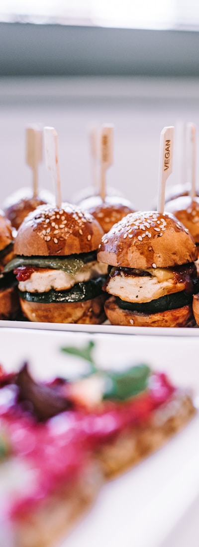 a row of mini sandwiches sitting on top of a white plate