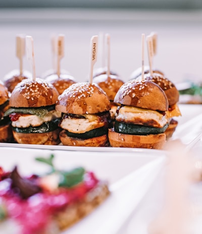 a row of mini sandwiches sitting on top of a white plate