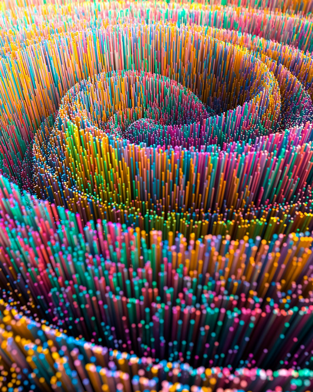 a large group of multicolored pencils are arranged in a spiral