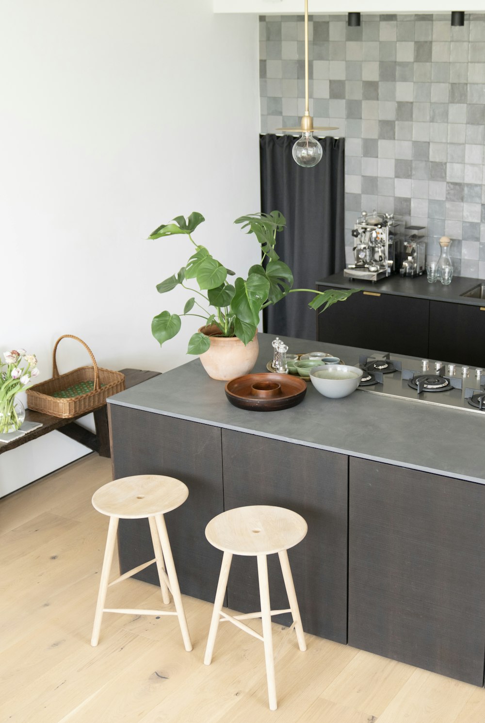 a kitchen with a counter, stools and a potted plant