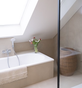 a white bath tub sitting under a window next to a sink