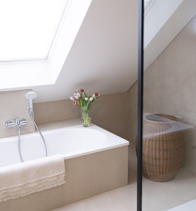 a white bath tub sitting under a window next to a sink