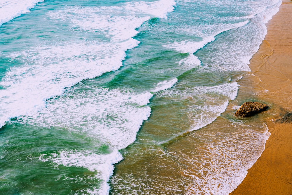 an aerial view of a beach with waves coming in