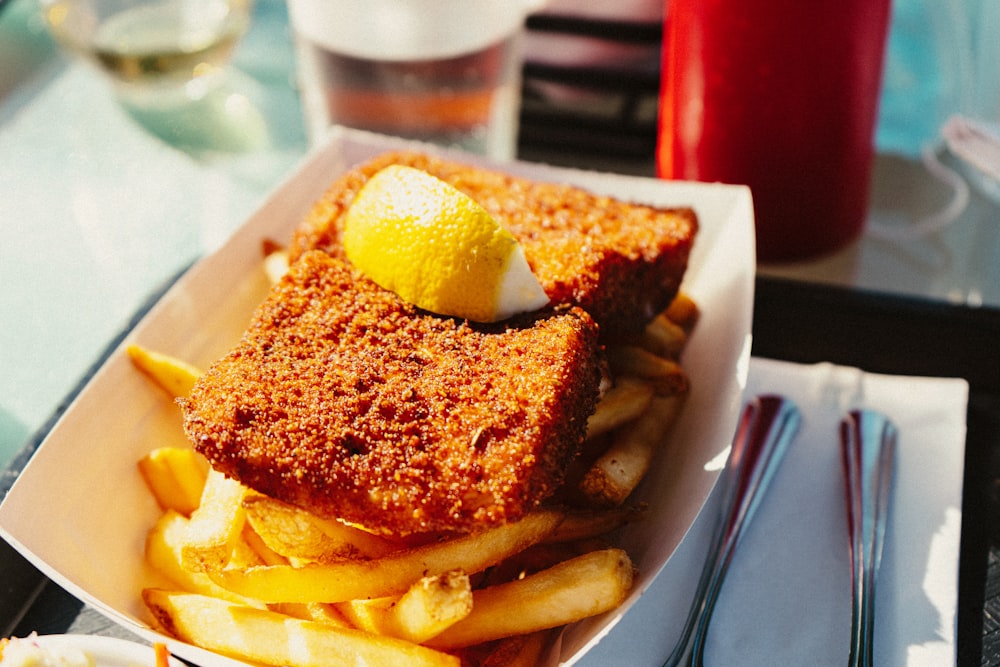 a plate of french fries with a lemon on top