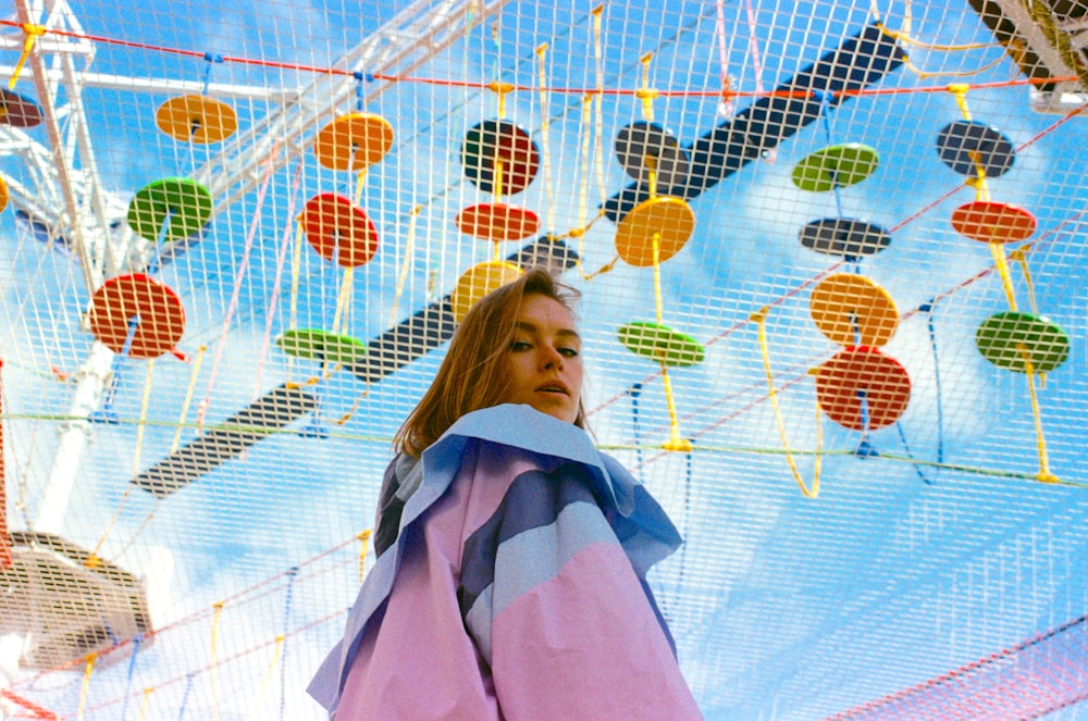 a woman standing under a colorfully decorated umbrella