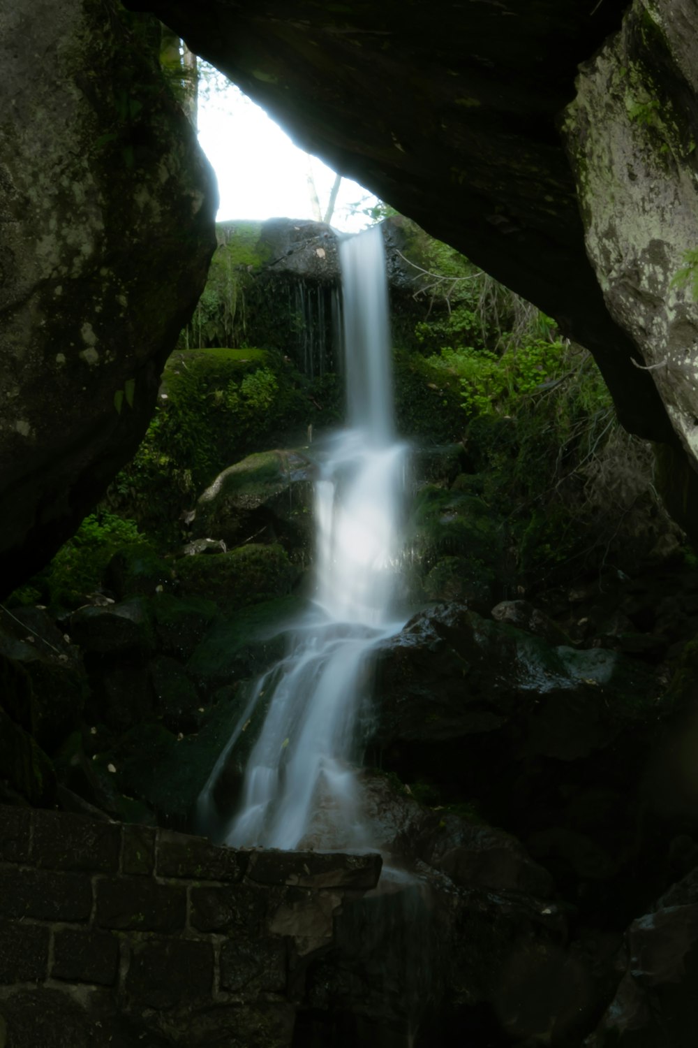 a small waterfall in the middle of a forest