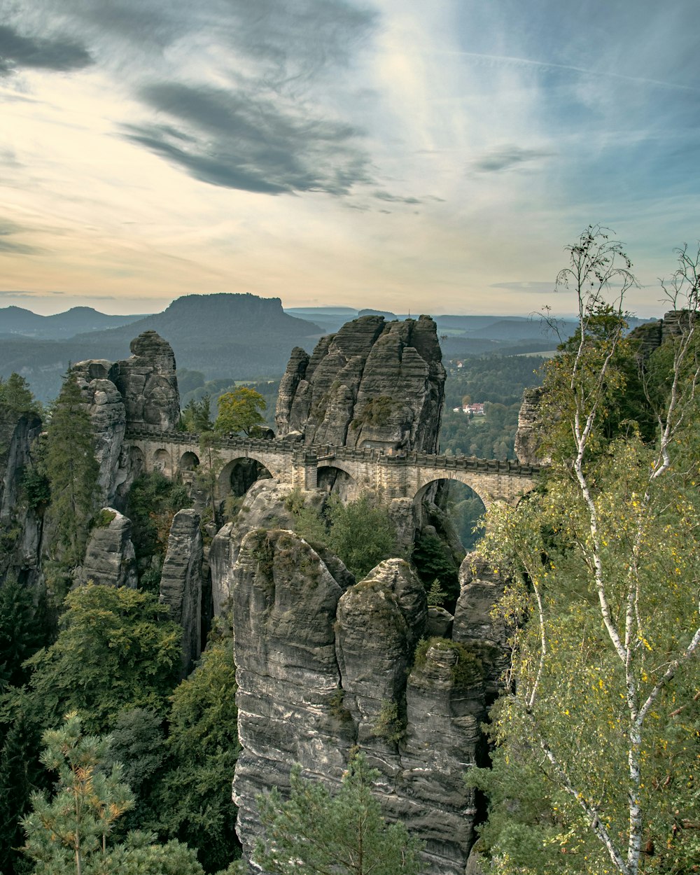 a scenic view of a bridge in the mountains