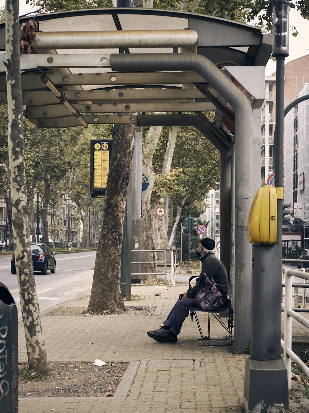 a man sitting in a chair on a sidewalk
