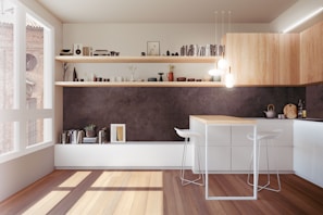 A modern kitchen with minimalist design featuring wooden cabinets and a center island with two white bar stools. Floating shelves are adorned with books, small plants, and decorative items. Natural light streams through a large window, enhancing the earthy and neutral color palette. Pendant lights hang above the island, adding a warm ambiance.