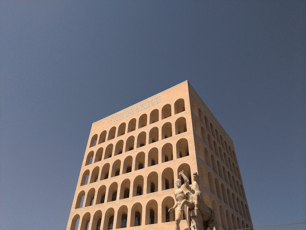 a tall building with a statue in front of it