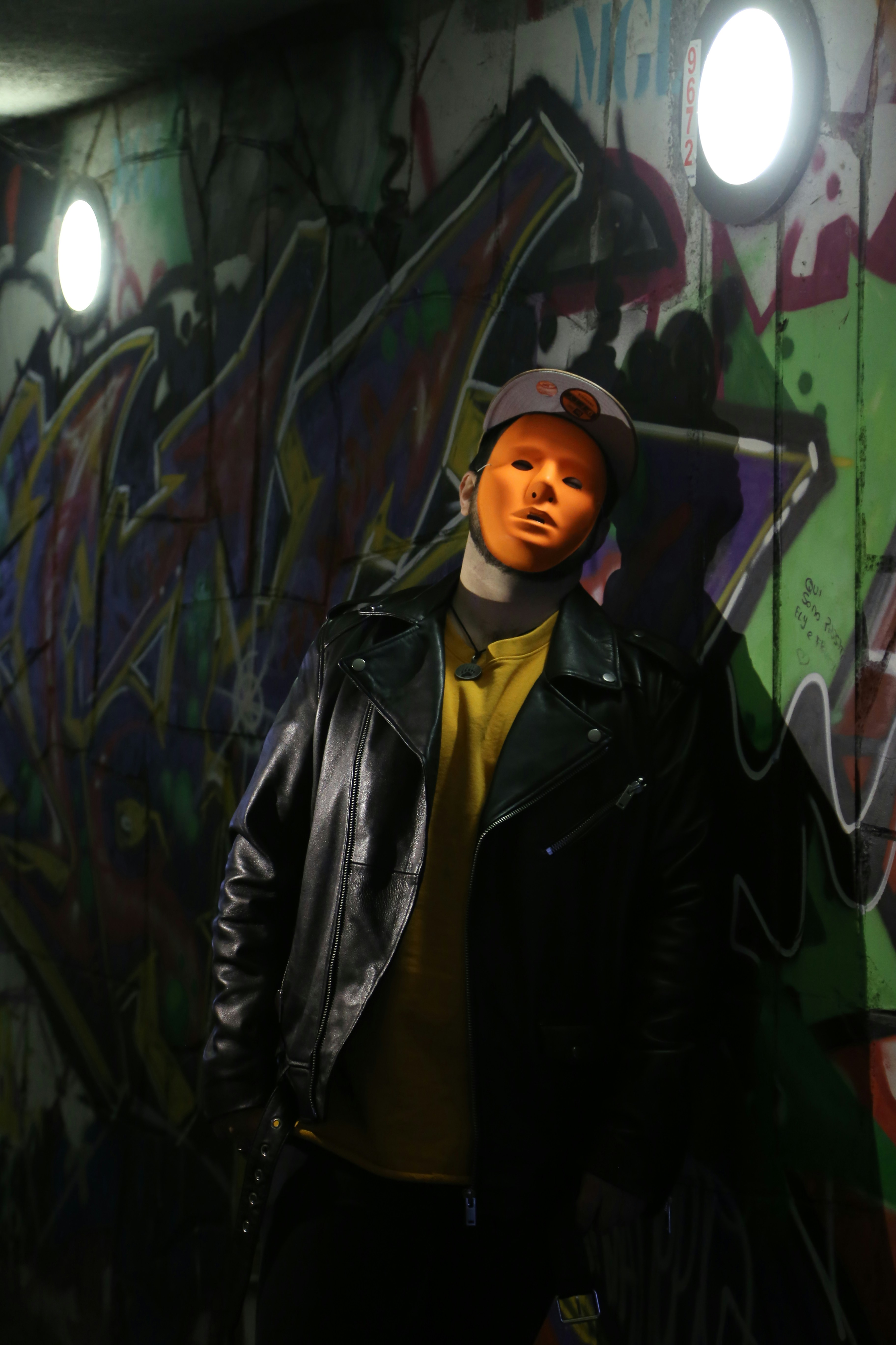 um manequim vestido com uma jaqueta de couro e chapéu está na frente de um