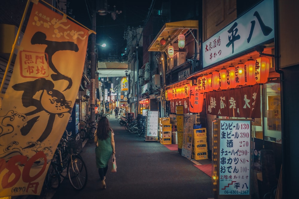 a woman walking down a street at night