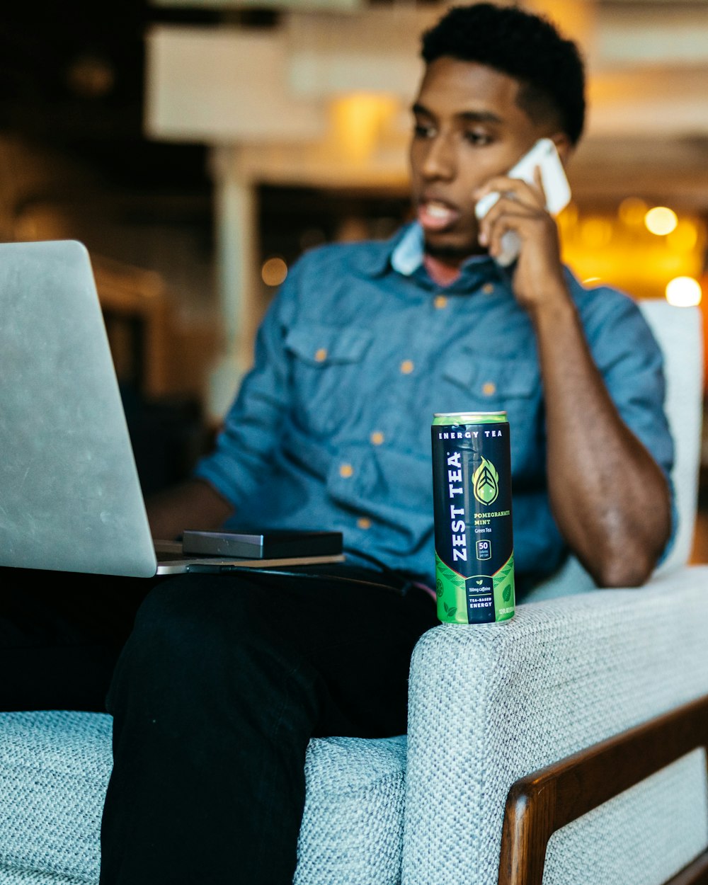 a man sitting in a chair talking on a cell phone