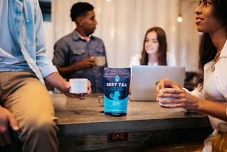 a group of people sitting around a table with a laptop