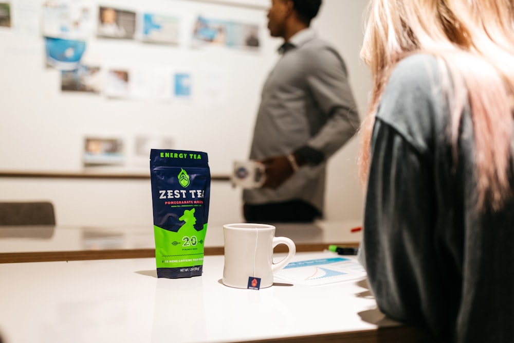 a coffee bag sitting on top of a table next to a cup