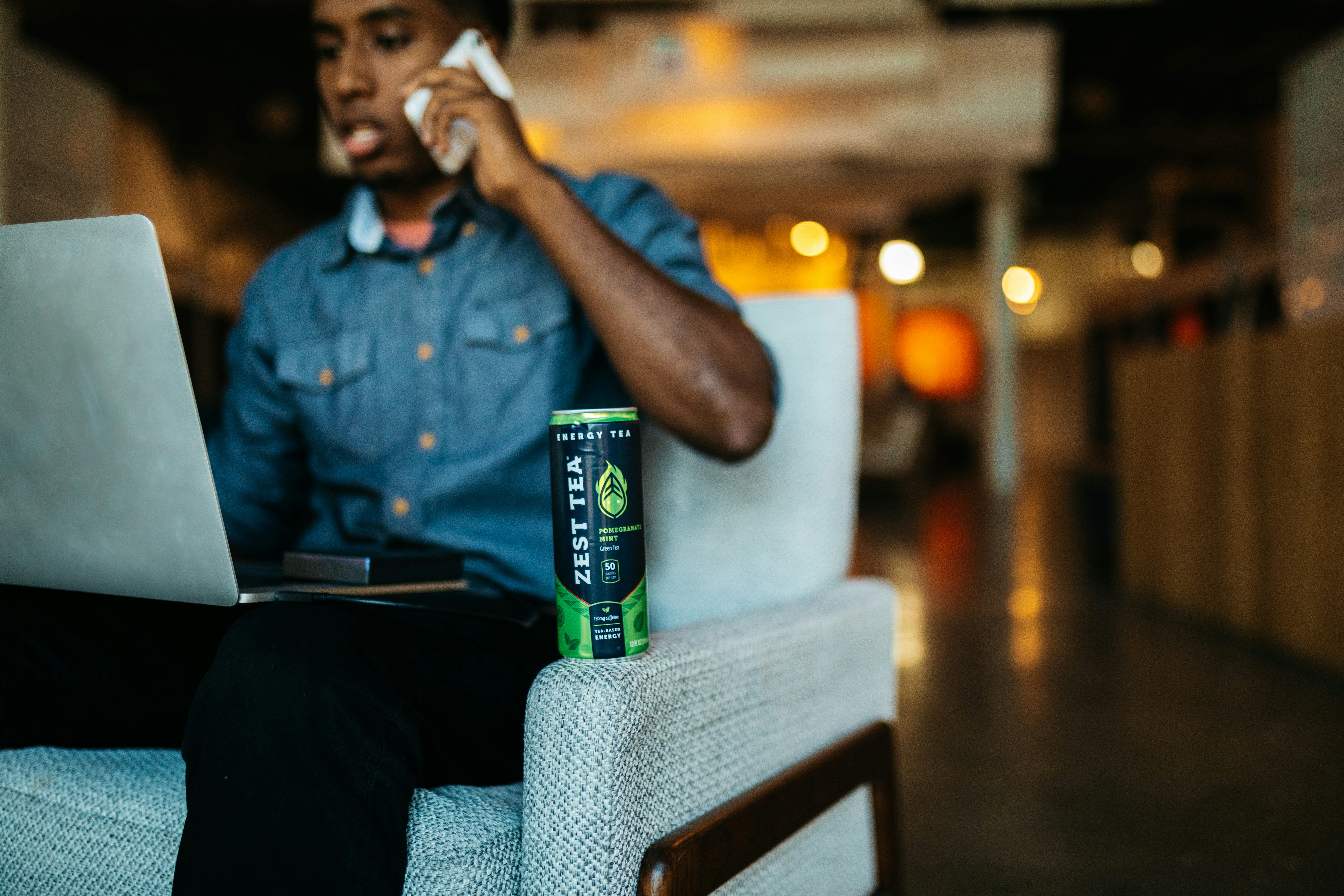 a man sitting in a chair talking on a cell phone