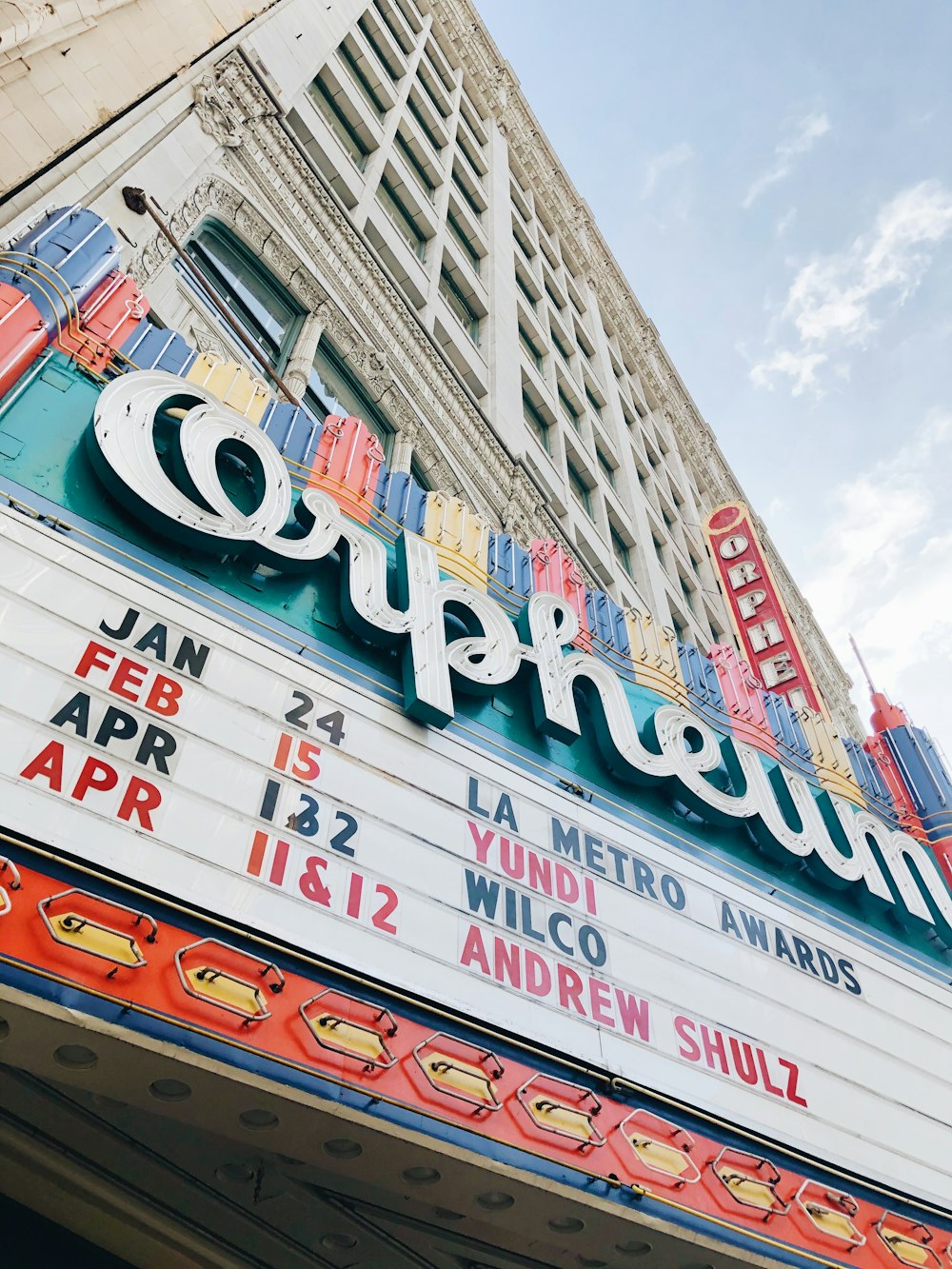 a theater marquee with a clock on the side of it