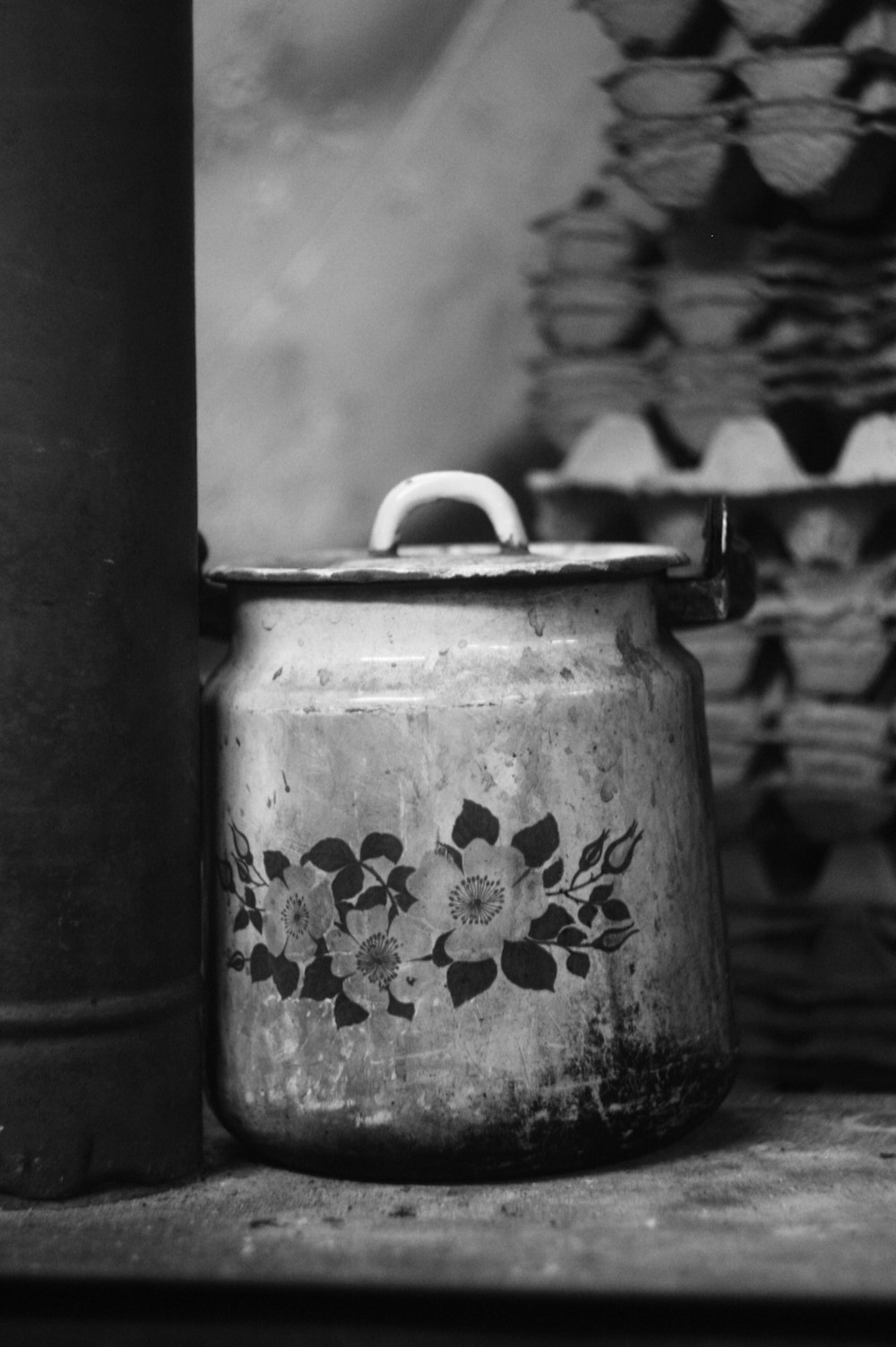 a black and white photo of a pot on a shelf