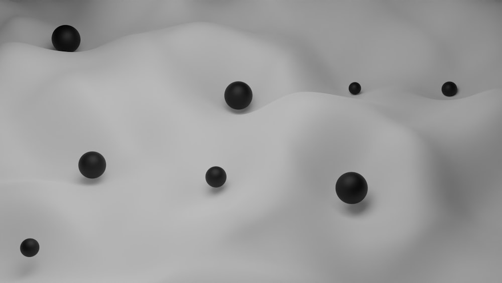 a group of black balls sitting on top of a white surface