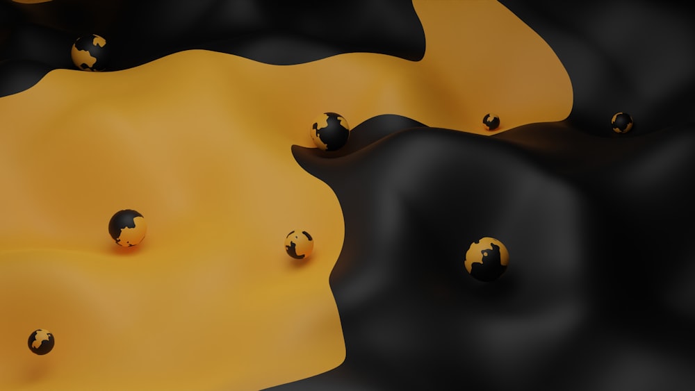 a group of black and yellow balls on a yellow surface