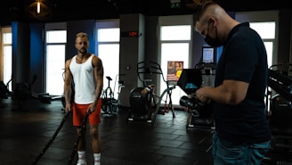 a man standing in a gym next to another man