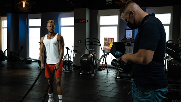 a man standing in a gym next to another man